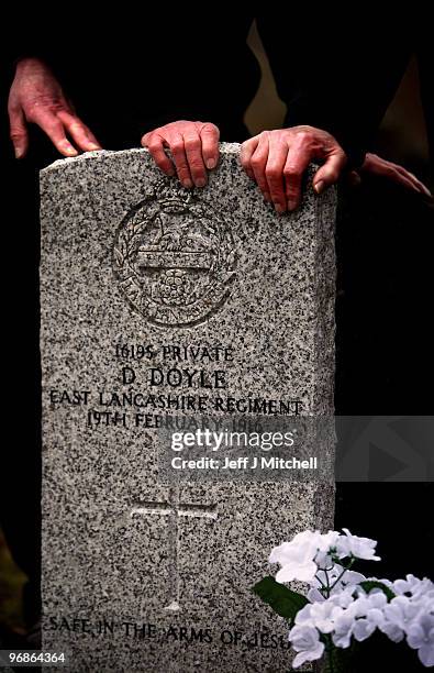 Private Dennis Doyle's nephews pay tribute at his grave on February 19, 2010 in Cambusnethan in Scotland. The Commonwealth War Graves Commission...