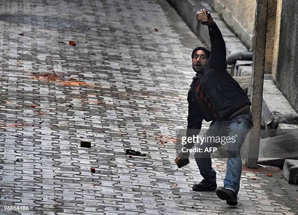 Kashmiri demonstrator throws stones during clashes with Indian police in Srinagar on February 11, 2010. A security lockdown and a general strike...