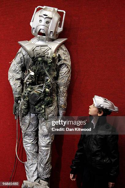 Charlie Sheaf 11, stands beside a Cyberman costume at Bonhams auction house on February 19, 2010 in London, England. A selection of items from the...