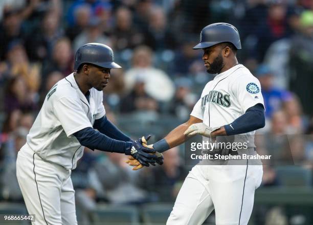 Denard Span of the Seattle Mariners is congratulated by Guillermo Heredia of the Seattle Mariners after scoring a run during a game against the Texas...