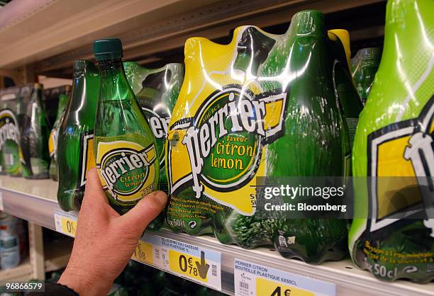 Customer takes a bottle of Perrier water in a supermarket in Paris, France, on Friday, Feb. 19, 2010. Nestle, the bottler of Perrier and Vittel, said...