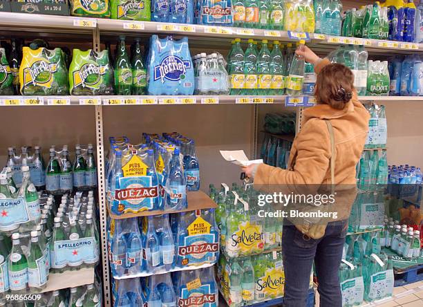 Customer buys water in a supermarket in Paris, France, on Friday, Feb. 19, 2010. Nestle, the bottler of Perrier and Vittel, said sales growth slowed...