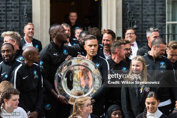 Robbie Williams, holding an official plaque, is joined by Olympic chapions Sir Mo Farah and Usain Bolt together with a host of celebrities,...