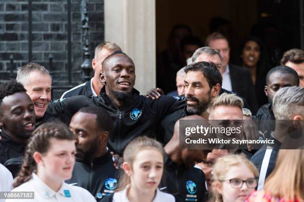 Olympic chapion Usain Bolt and former professional football player Robert Pires gather with teams, ambassadors and volunteers outside 10 Downing...