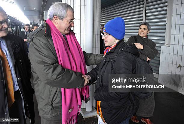 Le président sortant du Conseil régional d' Ile-de-France, le socialiste Jean-Paul Huchon , serre la main d'un voyageur à son arrivée à Evry le 18...