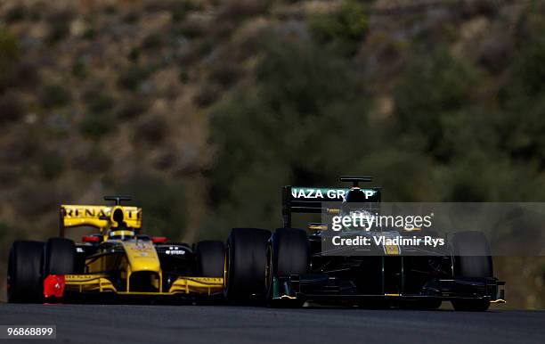 Heikki Kovalainen of Finland and Lotus drives followed by Robert Kubica of Poland and Renault during winter testing at the Circuito De Jerez on...