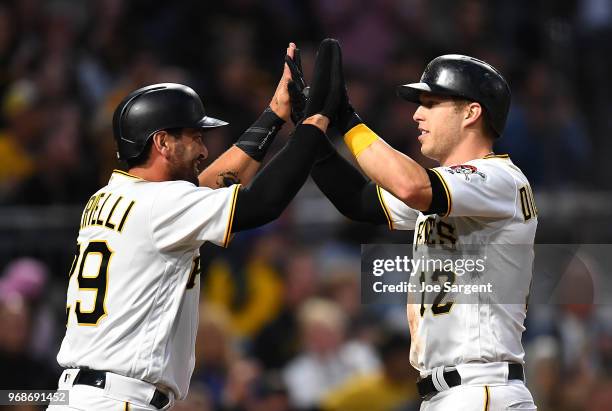 Francisco Cervelli and Corey Dickerson of the Pittsburgh Pirates celebrate after scoring during the fourth inning against the Los Angeles Dodgers at...