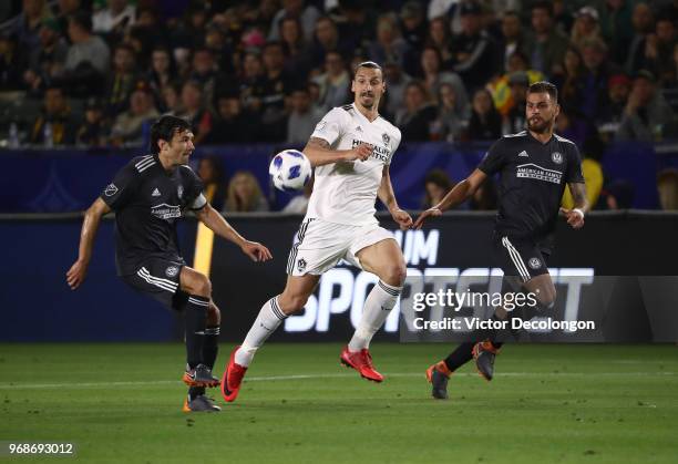 Zlatan Ibrahimovic of Los Angeles Galaxy and Leandro Gonzalez of Atlanta United pursue the play as Michael Parkhurst of Atlanta United plays the...