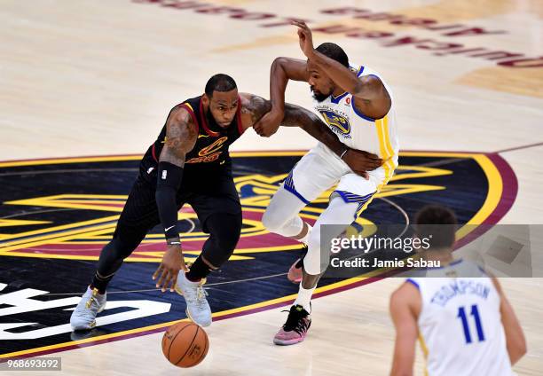 LeBron James of the Cleveland Cavaliers drives to the basket defended by Kevin Durant of the Golden State Warriors in the first quarter during Game...