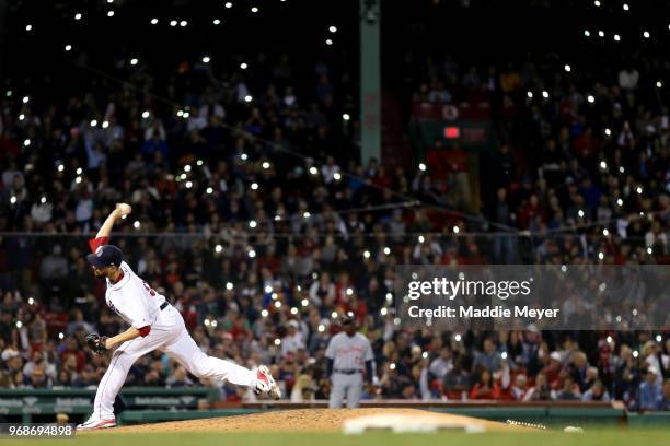 Fans shine the lights on their cell phones in the stands as Matt Barnes of the Boston Red Sox pitches against the Detroit Tigers during the seventh...