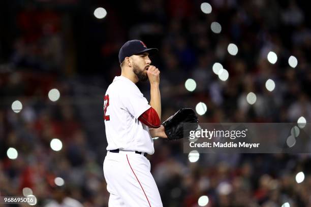 Fans shine the lights on their cell phones in the stands as Matt Barnes of the Boston Red Sox looks on during the seventh inning against the Detroit...