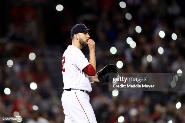 Fans shine the lights on their cell phones in the stands as Matt Barnes of the Boston Red Sox looks on during the seventh inning against the Detroit...