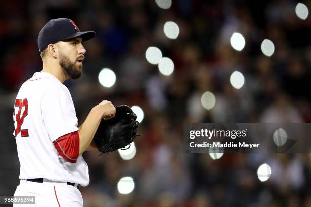 Fans shine the lights on their cell phones in the stands as Matt Barnes of the Boston Red Sox looks on during the seventh inning against the Detroit...