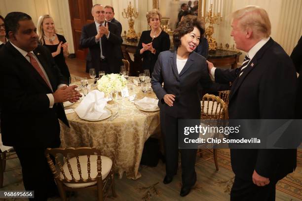 President Donald Trump greets Secretary of Transportation Elaine Chao and other guests while hosting an Iftar dinner in the State Dining Room at the...