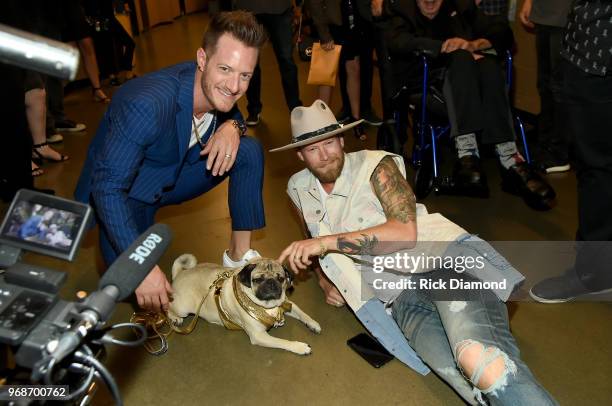 Tyler Hubbard and Brian Kelley of musical group Florida Georgia Line take photos with Doug The Pug at the 2018 CMT Music Awards - Backstage &...