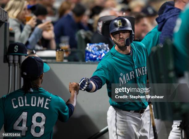 Relief pitcher Alex Colome of the Seattle Mariners is congratulated by Mitch Haniger of the Seattle Mariners in the dugout during a game against the...