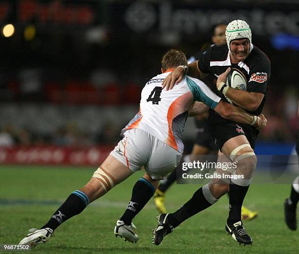 Steven Sykes is tackled by Nico Breedt during the Super 14 match between The Sharks and Vodacom Cheetahs from Absa Stadium on February 19, 2010 in...