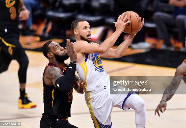 Stephen Curry of the Golden State Warriors attempts a layup defended by LeBron James of the Cleveland Cavaliers in the third quarter during Game...