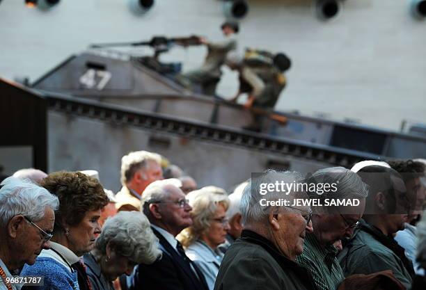 Iwo Jima veterans and other attendees react as the Marine Corps band play the national anthem during a ceremony commemorating the 65th Anniversary of...