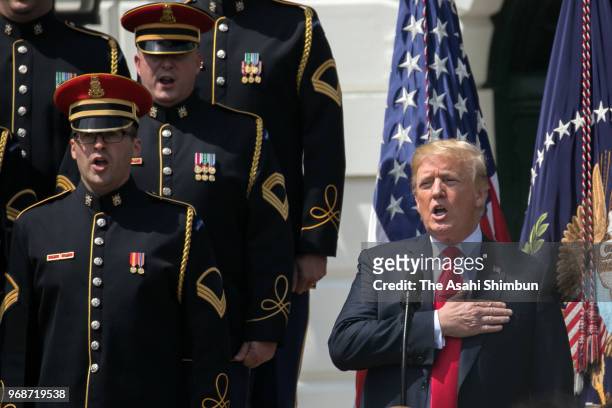 President Donald Trump sings the national anthem with a U.S. Army chorus during a "Celebration of America" event on the south lawn of the White House...