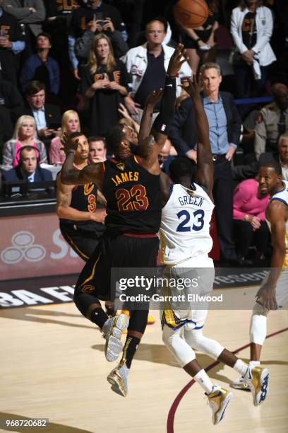 LeBron James of the Cleveland Cavaliers shoots a three pointer over Draymond Green of the Golden State Warriors during Game Three of the 2018 NBA...