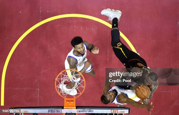 LeBron James of the Cleveland Cavaliers attempts a layup over Jordan Bell and Kevin Durant of the Golden State Warriors in the second quarter during...