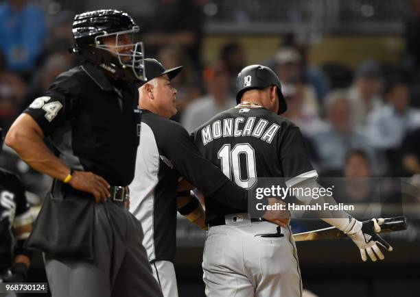 Manager Rick Renteria of the Chicago White Sox leads Yoan Moncada back to the dugout after striking out against the Minnesota Twins as home plate...