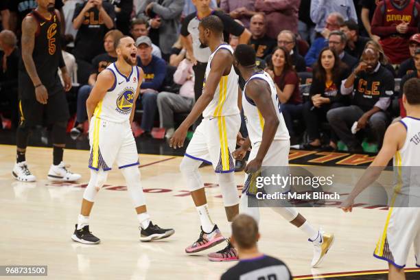 Stephen Curry and Draymond Green yell and celebrate with Kevin Durant of the Golden State Warriors in Game Three of the 2018 NBA Finals against the...