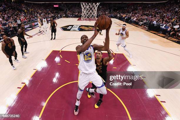 Kevin Durant of the Golden State Warriors attempts a layup defended by George Hill of the Cleveland Cavaliers in the second half during Game Three of...