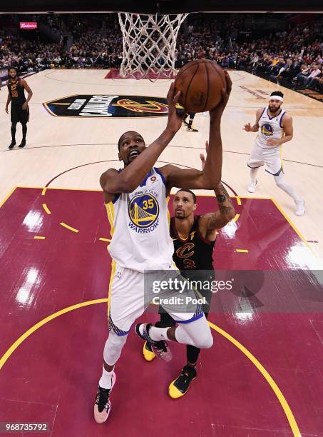 Kevin Durant of the Golden State Warriors attempts a layup defended by George Hill of the Cleveland Cavaliers in the second half during Game Three of...