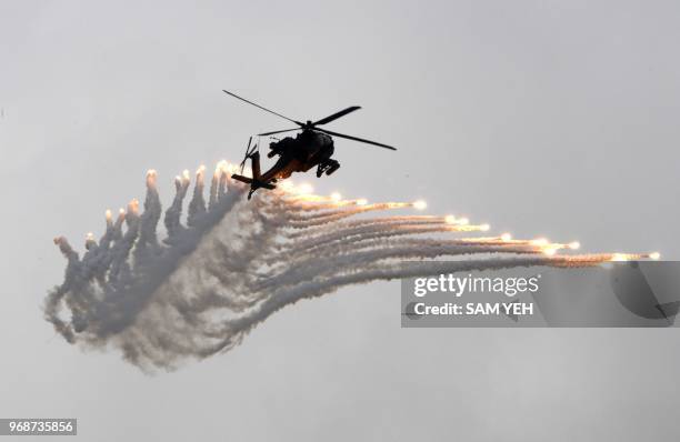 An AH-64 Apache attack helicopter releases flares during the Han Kuang drill at the Ching Chuan Kang air force base in Taichung, central Taiwan, on...