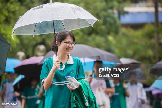 Candidate enters an exam site with an umbrella for the National College Entrance Examination at Zhong Yuan High School on June 7, 2018 in Guangzhou,...