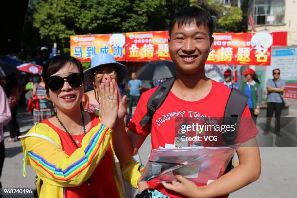 Candidate gives a high-five to his mother before entering an exam site for the National College Entrance Examination at Huaibei No.2 Middle School of...