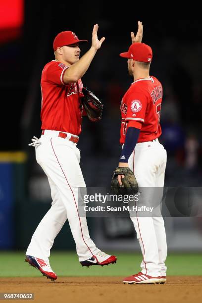 Mike Trout and Zack Cozart of the Los Angeles Angels of Anaheim celebrate defeating the Kansas City Royals 4-3 in a game at Angel Stadium on June 6,...