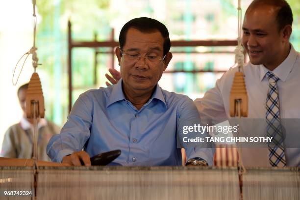 Cambodian Prime Minister Hun Sen weaves a traditional Khmer "krama during an event to set a record for the world's longest scarf with the length of...