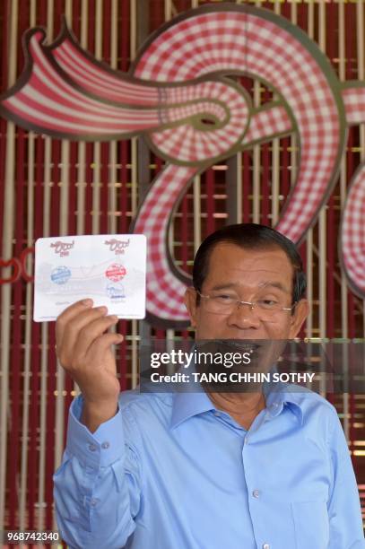 Cambodian Prime Minister Hun Sen, shows a card certifying that he participated in weaving the traditional Khmer "krama during an event to set a...