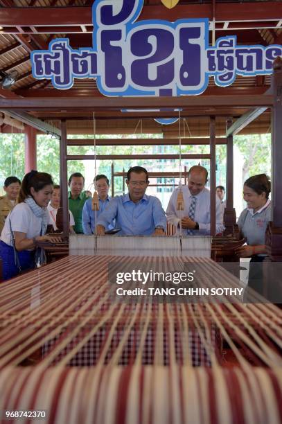 Cambodian Prime Minister Hun Sen weaves a traditional Khmer "krama during an event to set a record for the world's longest scarf with the length of...