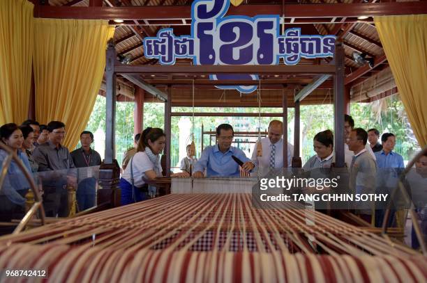 Cambodian Prime Minister Hun Sen weaves a traditional Khmer "krama during an event to set a record for the world's longest scarf with the length of...