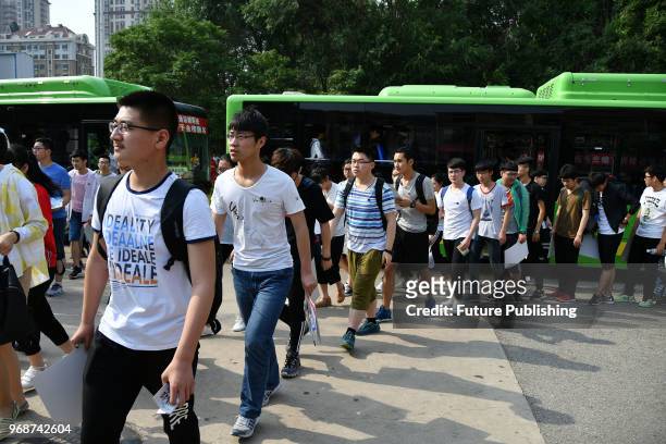 Examinees off a bus march into a venue of the annual National College Entrance Exam in Yantai in east China's Shandong province Thursday, June 07,...