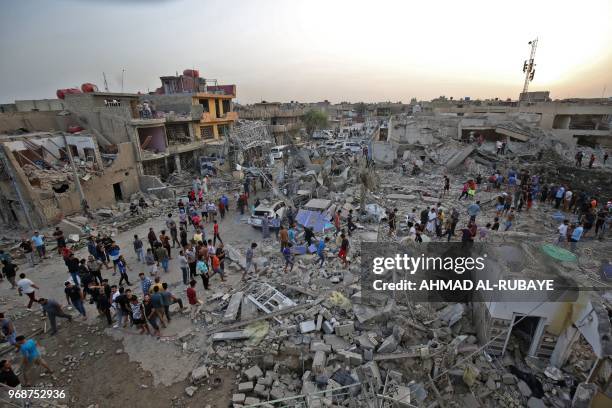 Iraqis inspect the aftermath of an explosion in Baghdad's Sadr City district on June 7, 2018. At least 16 people were killed and dozens injured after...