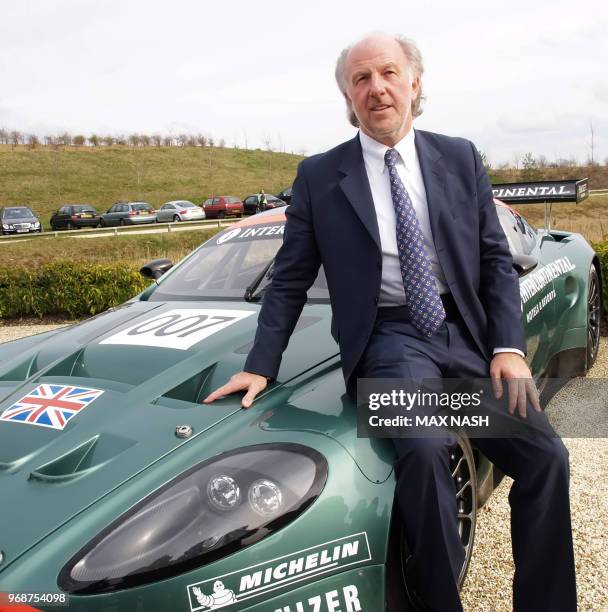 The new non-executive Chairman of the British Aston Martin sports car firm David Richards sits on one of the firms cars during a press conference...