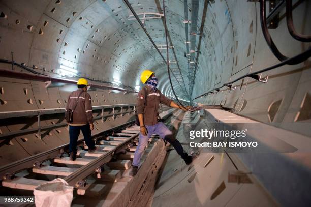 Engineers and workers are seen in the tunnels of Jakarta's MRT construction project in Jakarta on June 7 2018. - Deep below Jakarta's traffic-choked...