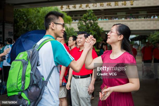 Candidate holds her mother's hand before entering an exam site for the National College Entrance Examination on June 7, 2018 in Guangzhou, Guangdong...