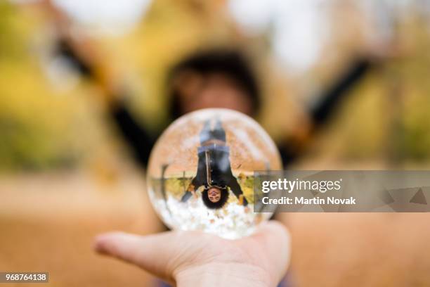 woman in park playing with crystal ball - crystal ball stock-fotos und bilder