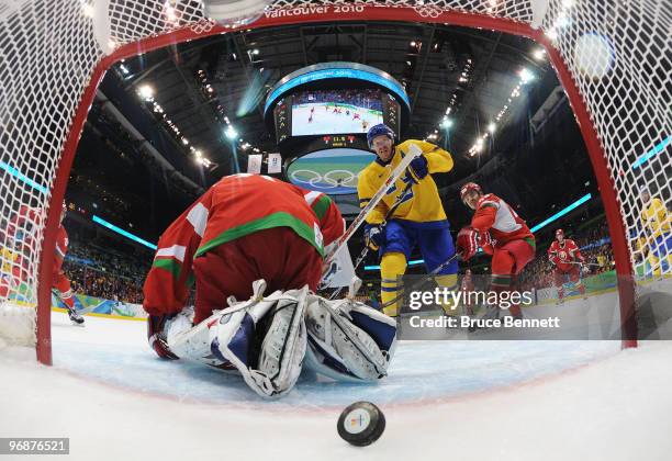 Daniel Alfredsson of Sweden scores a goal past goalkeeper Andrei Mezin of Belarus during the ice hockey men's preliminary game on day 8 of the...