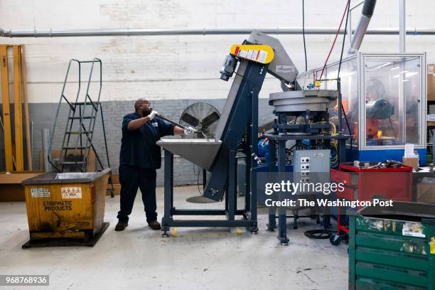 Lonnie Harris loads steel parts into an end finishing machine at Stripmatic Products, Inc. In Cleveland, United States on June 2018.