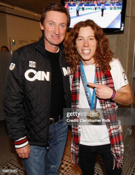 Shaun White of the United States poses with his men's halfpipe Olympic gold medal and hockey great Wayne Gretzky at the USA House on February 18,...