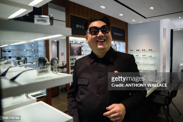 Kim Jong Un impersonator, who goes by the name Howard X, smiles as he tries on a pair of sunglasses in a shop while dressed up as the North Korean...
