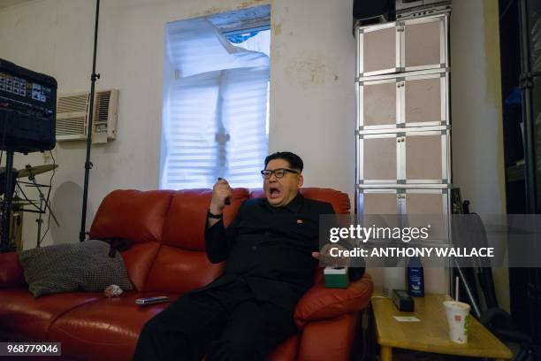 Kim Jong Un impersonator, who goes by the name Howard X, reacts as he pretends to press a red button while dressed up as the North Korean leader at...