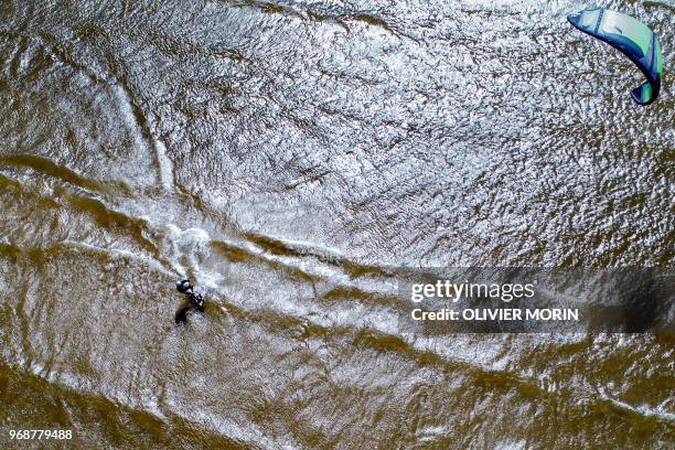 Former Finnish Olympic gymnastics athlete in Rome and Tokyo , Kauko Heikkinen kitesurfs in Storsand, western Finland, on May 23, 2018. - At 80 years...